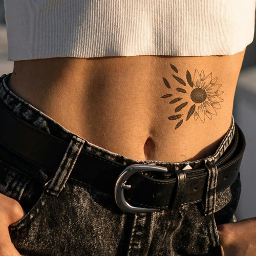 Tatouage tournesol et plume pour femme sur le ventre